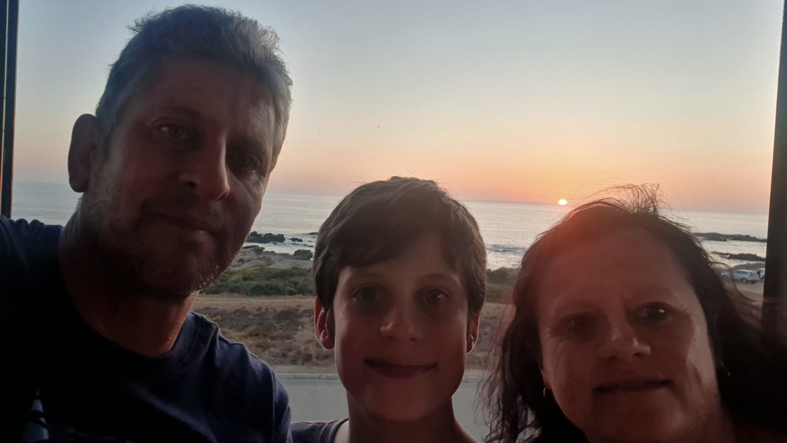 A family sunset selfie by the ocean